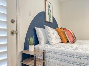 a bedroom with a bed with pillows and a table at Casa Del Luna in Biltmore in Phoenix