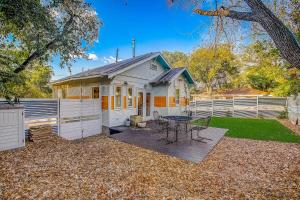 a white house with a table and a fence at Earn Your Vacation Stripes in Austin