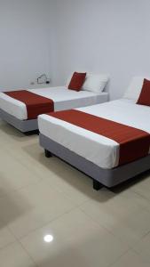 Zwei Betten befinden sich in einem Zimmer in der Unterkunft DEPARTAMENTOS MARCECILIA DE 2 y 3 HABITACIONES EN EL CENTRO DE MANTA in Manta