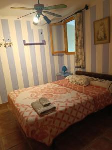 1 dormitorio con 1 cama y ventilador de techo en La Casassa, en Les Coves de Vinroma