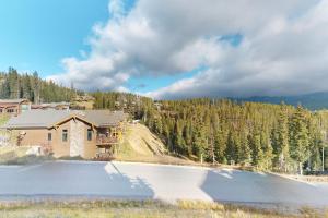 a house with a lake in front of a mountain at Saddle Ridge B2 in Big Sky