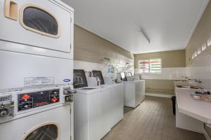 a laundry room with white washers and dryers at River Retreat Home & Holiday Park in Tweed Heads