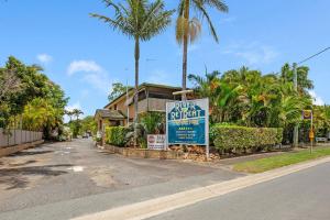 a sign for a hotel on a street with palm trees at River Retreat Home & Holiday Park in Tweed Heads