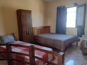 a small bedroom with two beds and a window at Sobrado aconchegante in Ilhéus