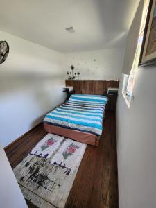 um pequeno quarto com uma cama e um tapete em Casa Conteiner em Salta