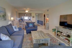 ein Wohnzimmer mit einem blauen Sofa und einem Tisch in der Unterkunft El Matador 113 - Ground floor end unit with easy access to all amenities in Fort Walton Beach