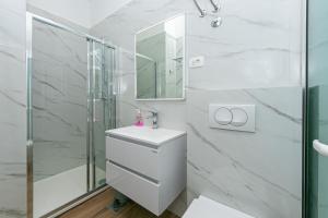 a white bathroom with a shower and a sink at Apartments by the sea Drasnice, Makarska - 6652 in Drasnice