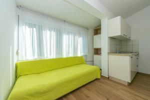 a yellow couch in a room with a window at Apartments by the sea Drasnice, Makarska - 6652 in Drasnice