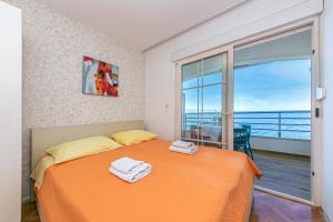 德拉辛歇的住宿－Apartments by the sea Drasnice, Makarska - 6652，一间带橙色床的卧室和一个阳台