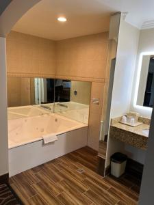 a large bathroom with a tub and a sink at Walnut Inn & Suites West Covina in West Covina