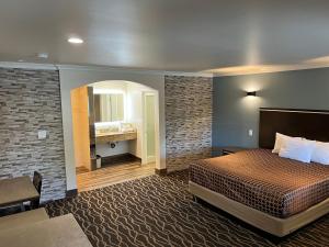 ウェストコビーナにあるWalnut Inn & Suites West Covinaのベッドとバスルーム付きのホテルルームです。