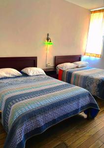 昆卡的住宿－Hostal la Merced，一间卧室配有两张床和一盏灯。