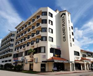 a large white building with the name of the hotel at Grand Plaza Hotel in Tumon