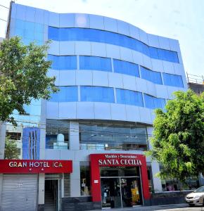 un gran edificio de cristal con una señal roja delante de él en Gran Hotel Ica, en Ica