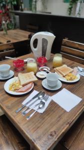 una mesa de madera con platos de comida y utensilios en Hostal la Merced, en Cuenca