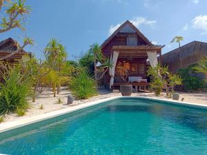 a swimming pool in front of a villa at Loedi Bungalows Rote in Nembrala