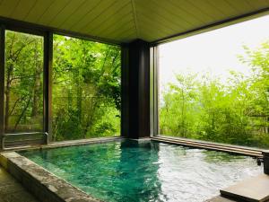 una piscina en una casa con ventanas en Lake Side Nikko Hotel en Nikko