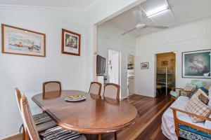 a dining room and living room with a table and chairs at Choongurra in Noosaville