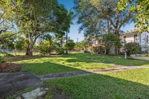 a yard with grass and trees and a house at Choongurra in Noosaville