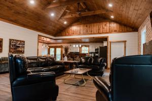 a living room with leather furniture and wooden ceilings at Bigfoots Retreat chalet in Gatlinburg +49 photos