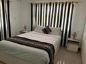 a bedroom with a large bed with black and white stripes at Bula Holiday Inn in Nadi