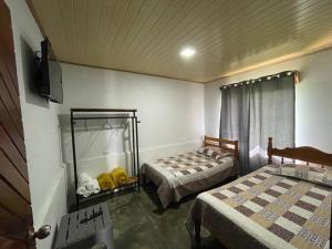 a bedroom with two beds and a television in it at Large & Confortable Family House in Fortuna