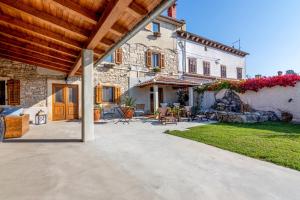 a stone house with a patio and a yard at Apartments and rooms with parking space Loborika, Pula - 12983 in Marčana