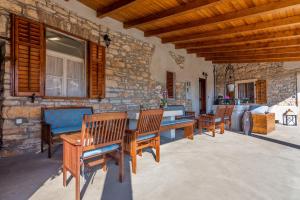 a patio with wooden chairs and a table and a stone wall at Apartments and rooms with parking space Loborika, Pula - 12983 in Marčana