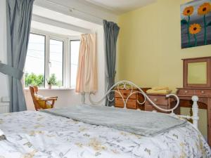 um quarto com uma cama e uma janela em Ashgrove Cottage em Dudbridge