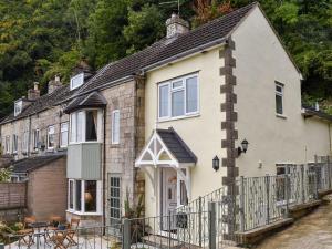 a house with a fence in front of it at Ashgrove Cottage in Dudbridge