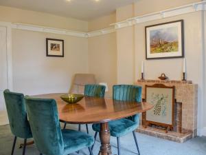 a dining room with a wooden table and blue chairs at Westholme in Saint Fillans