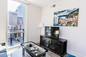 a living room with a large window and a tv at Uptown Charlotte 2BR Furnished Apartments apts in Charlotte
