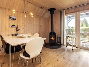 - une salle à manger avec une table et un poêle à bois dans l'établissement 5 person holiday home in Fr rup, à Tårup
