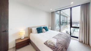 a bedroom with a bed and a large window at Luxury Penthouse with Astonishing Bay and City Views in Melbourne