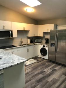 una cocina con armarios blancos y electrodomésticos de acero inoxidable en 2 Bedrooms Vacation Home, en Tampa