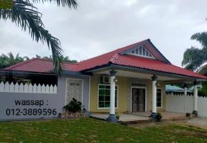 uma pequena casa amarela com um telhado vermelho em Villa Auliyya - MslimOnly em Kampong Sungai Leman