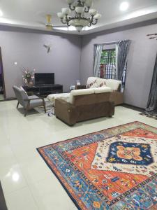 uma sala de estar com um sofá e um tapete em Villa Auliyya - MslimOnly em Kampong Sungai Leman