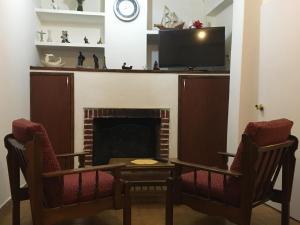 uma sala de estar com duas cadeiras e uma lareira em Cami III em Piriápolis