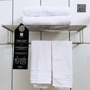wieszak na ręczniki z białymi ręcznikami w obiekcie Rua Hoteles Piura w mieście Piura