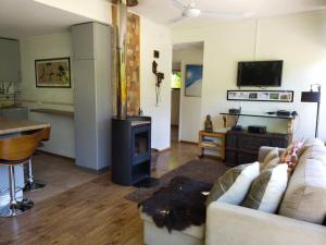 sala de estar con sofá y estufa de leña en Cabañas Nordic lodge en Chillán