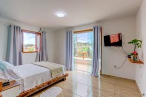 a bedroom with a bed and a flat screen tv at Pousada Canto de Zul in Itacaré +33 photos