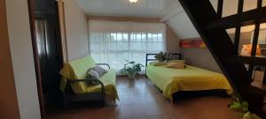 1 dormitorio con 1 cama, 1 silla y 1 ventana en El Nido Cerro Azul en Cerro Azul