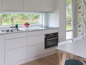 a kitchen with white cabinets and a sink and a window at 4 person holiday home in TRÄLÖVSLÄGE-By Traum in TrÃ¤slÃ¶vslÃ¤ge
