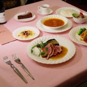 une table rose avec des assiettes de nourriture dans l'établissement Petit Hotel Shitaka, à Hakuba