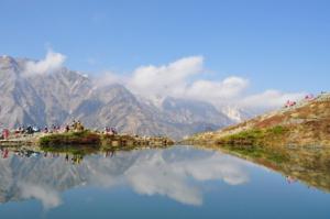 a group of people standing on a hill next to a body of water at Petit Hotel Shitaka in Hakuba