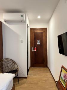 a room with a hallway with a door and a chair at Laholm Hotel - Apartment in Nha Trang