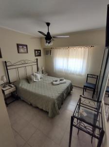a bedroom with a bed and a ceiling fan at Costa Norte Hostería in Colón