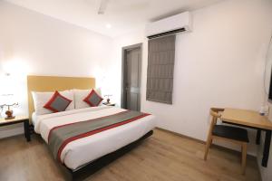 a hotel room with a bed and a desk and a bed sidx sidx at Hotel IP Residency Anand Vihar in New Delhi