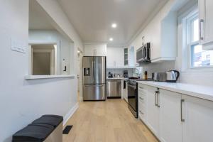 a kitchen with white cabinets and a stainless steel refrigerator at Cozy 4-Bdrm Pet-Friendly East Hamilton Escape in Hamilton