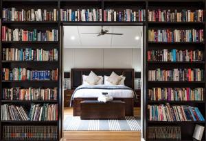 een slaapkamer met een bed en twee boekenplanken gevuld met boeken bij Kalinya Estate Platinum- Homestead, Lodge & Barn- up to 34 guests in Bargo